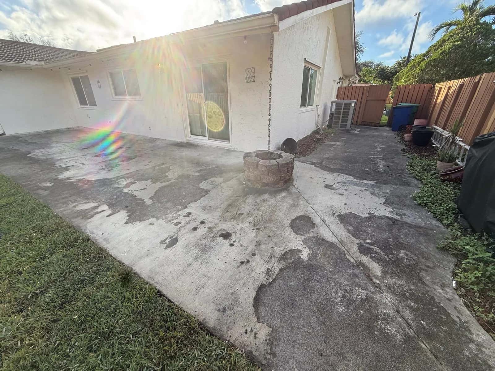 Concrete patio stained black with mildew before cleaning
