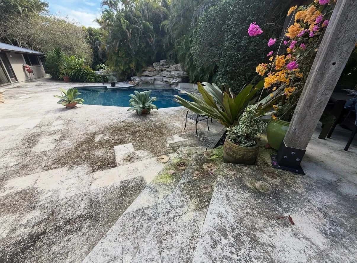 Travertine pool deck streaked with dirt and mildew before cleaning