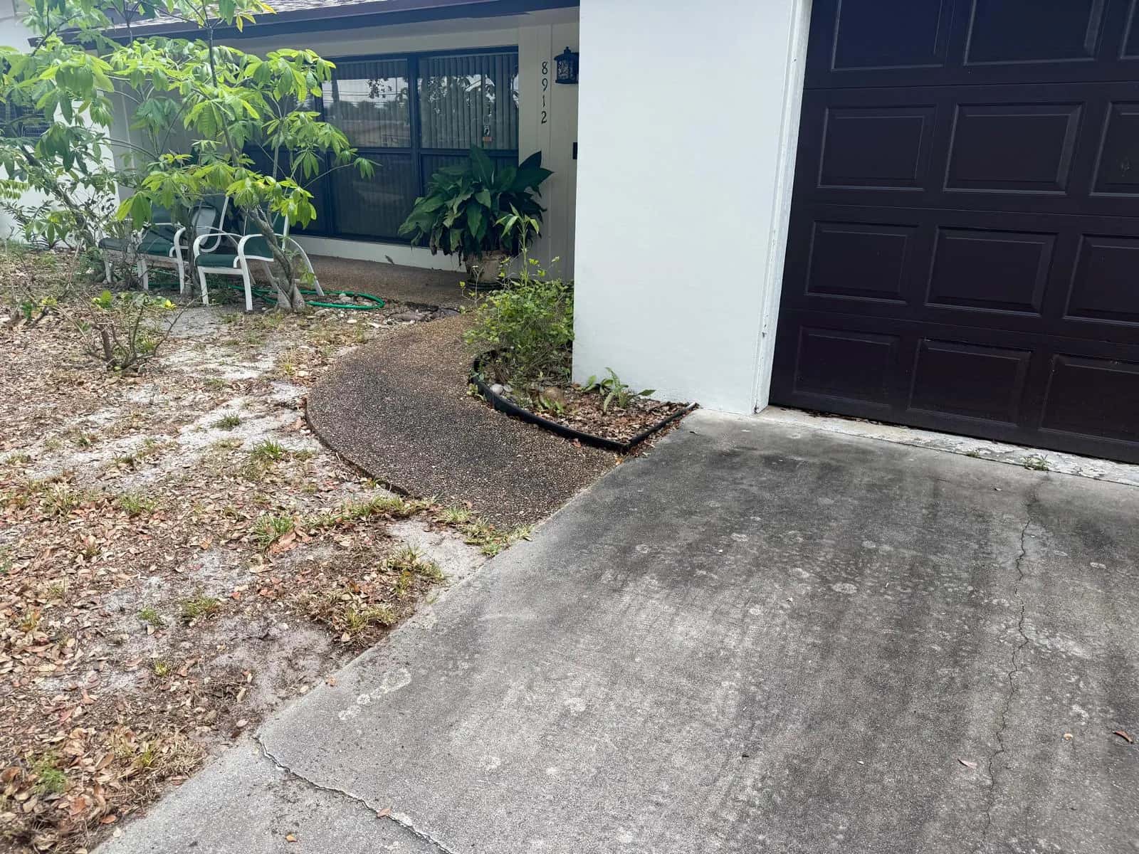 Dirty driveway and bare front yard before the refresh