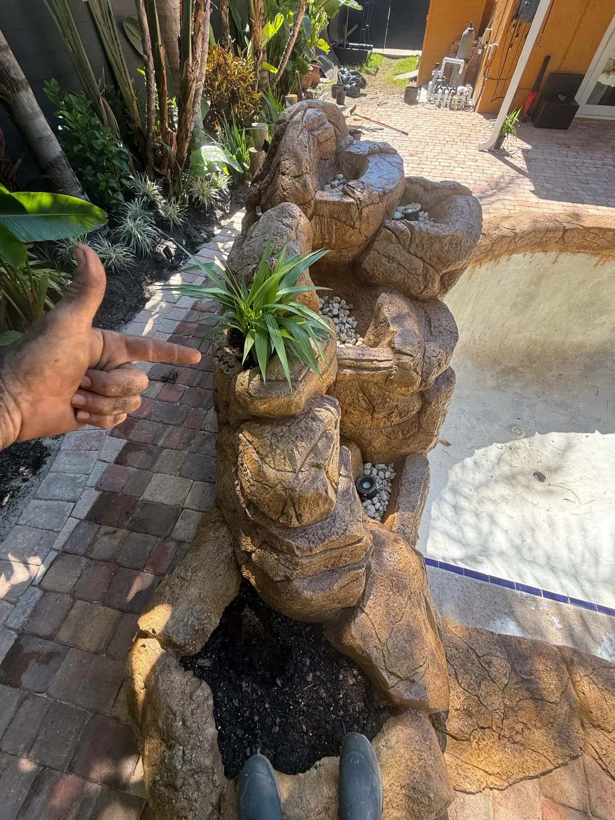 Sculpted rock waterfall with built-in planter