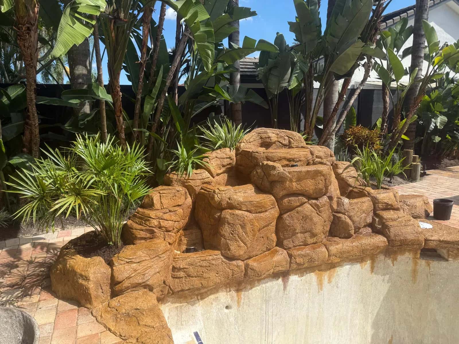 Custom rock waterfall built along a pool
