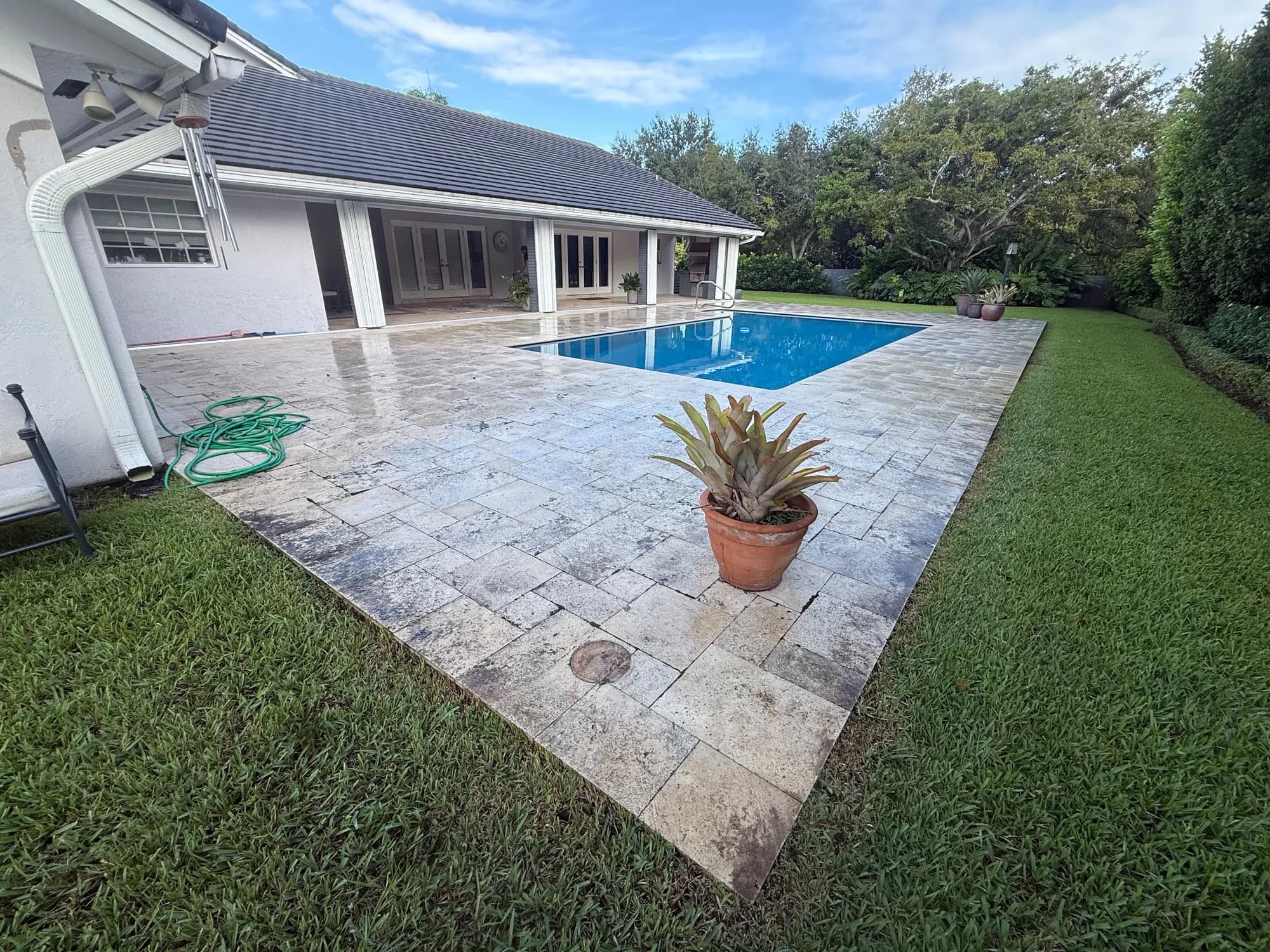 Gray, dirty pool deck pavers before pressure cleaning