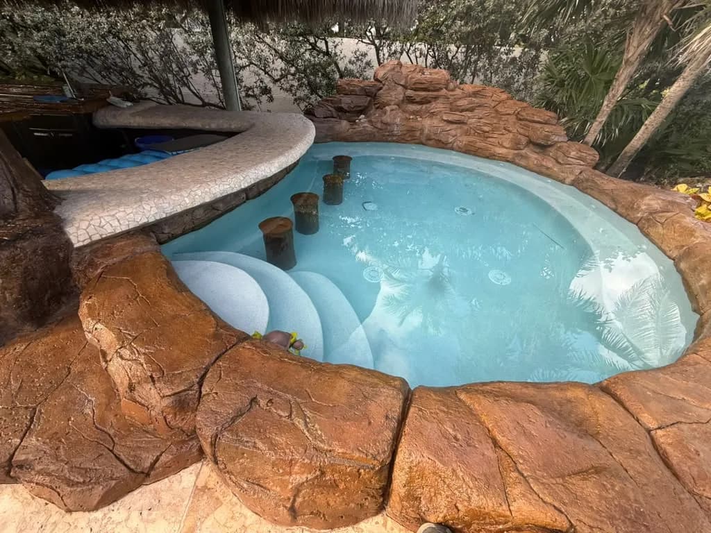 Custom rock grotto spa with sculpted stone edges