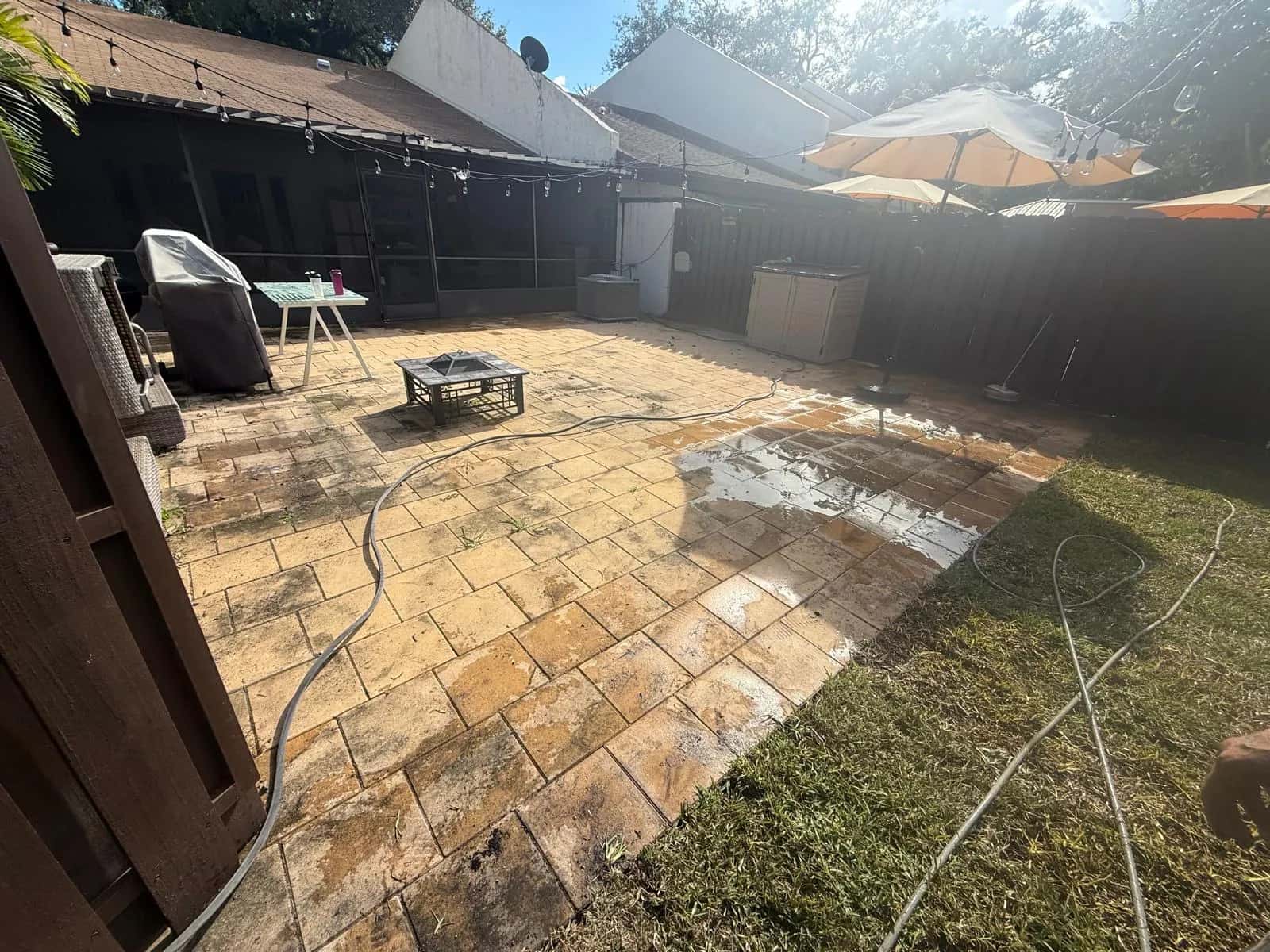 Backyard paver patio darkened with grime before cleaning