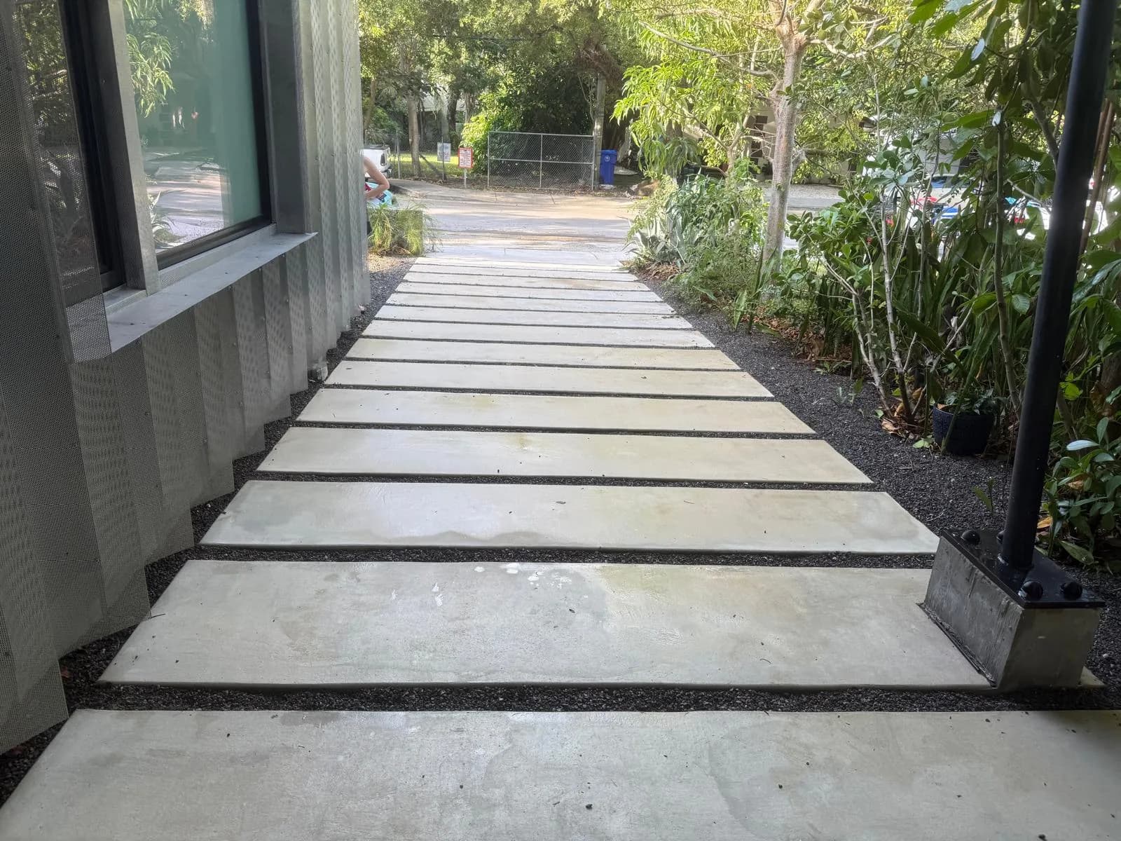 Modern concrete slab walkway with black gravel joints after cleaning — Looking New, serving Coral Springs