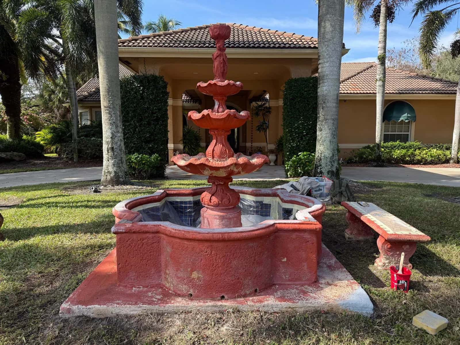 Faded, chipped red tiered fountain before restoration